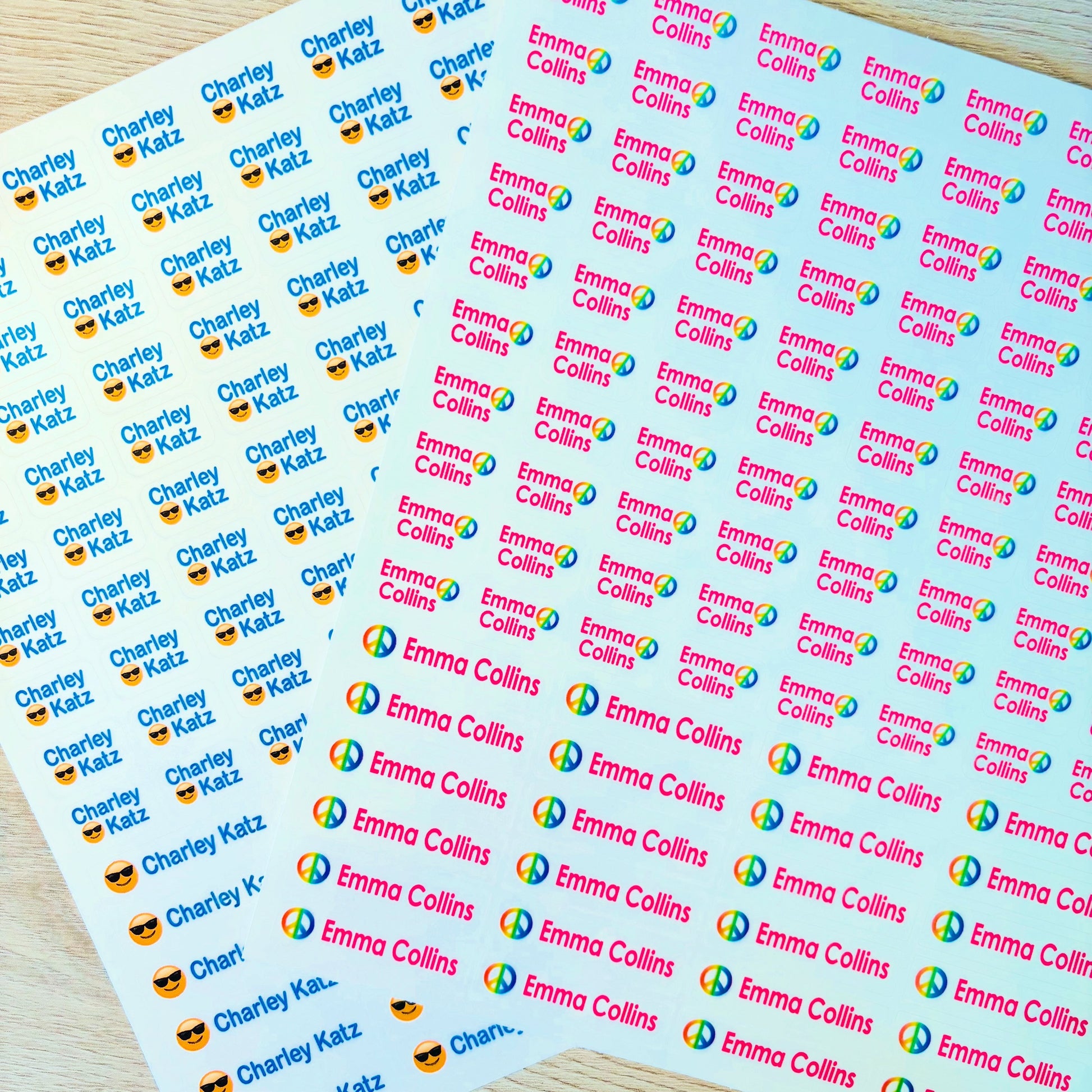 Sheets of personalized stickers with names and logos on a wooden surface